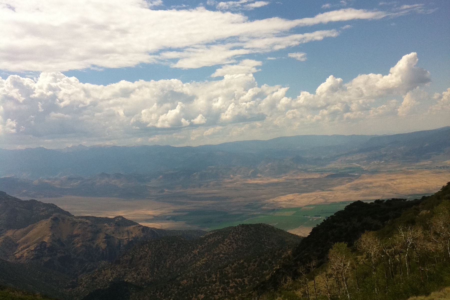 Sevier Valley seen from the mountains above it, farmland running the length of the valley floor.